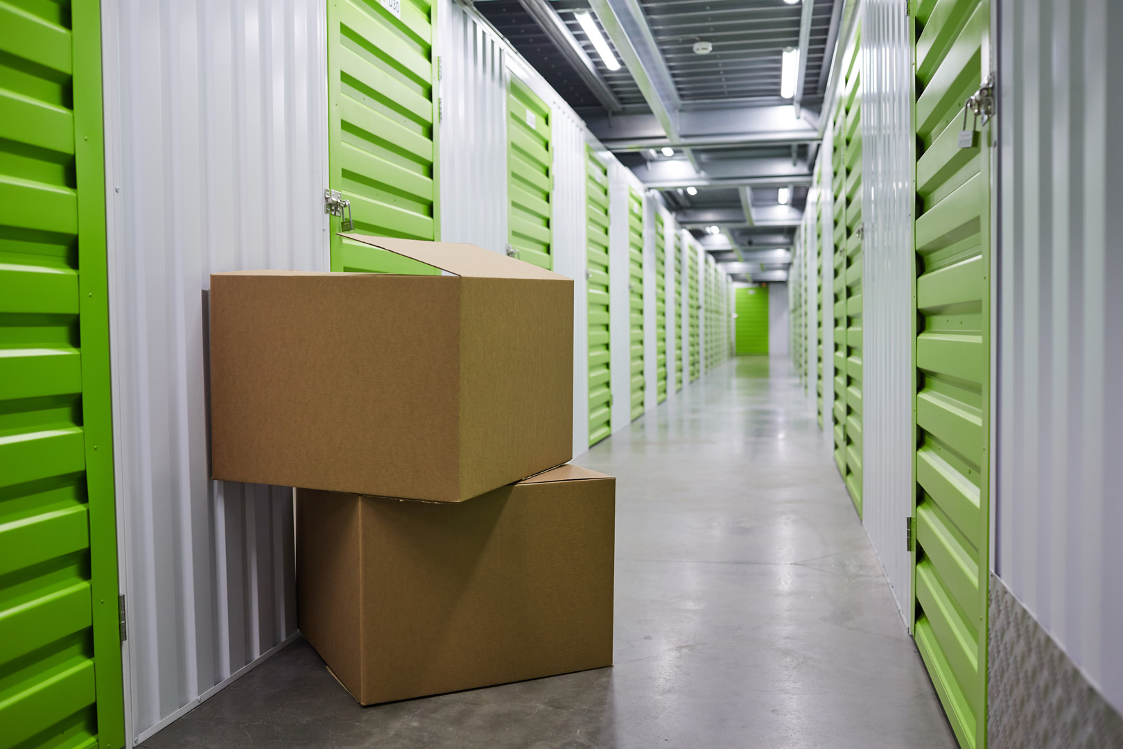 Storage unit hallway with stacked cardboard boxes